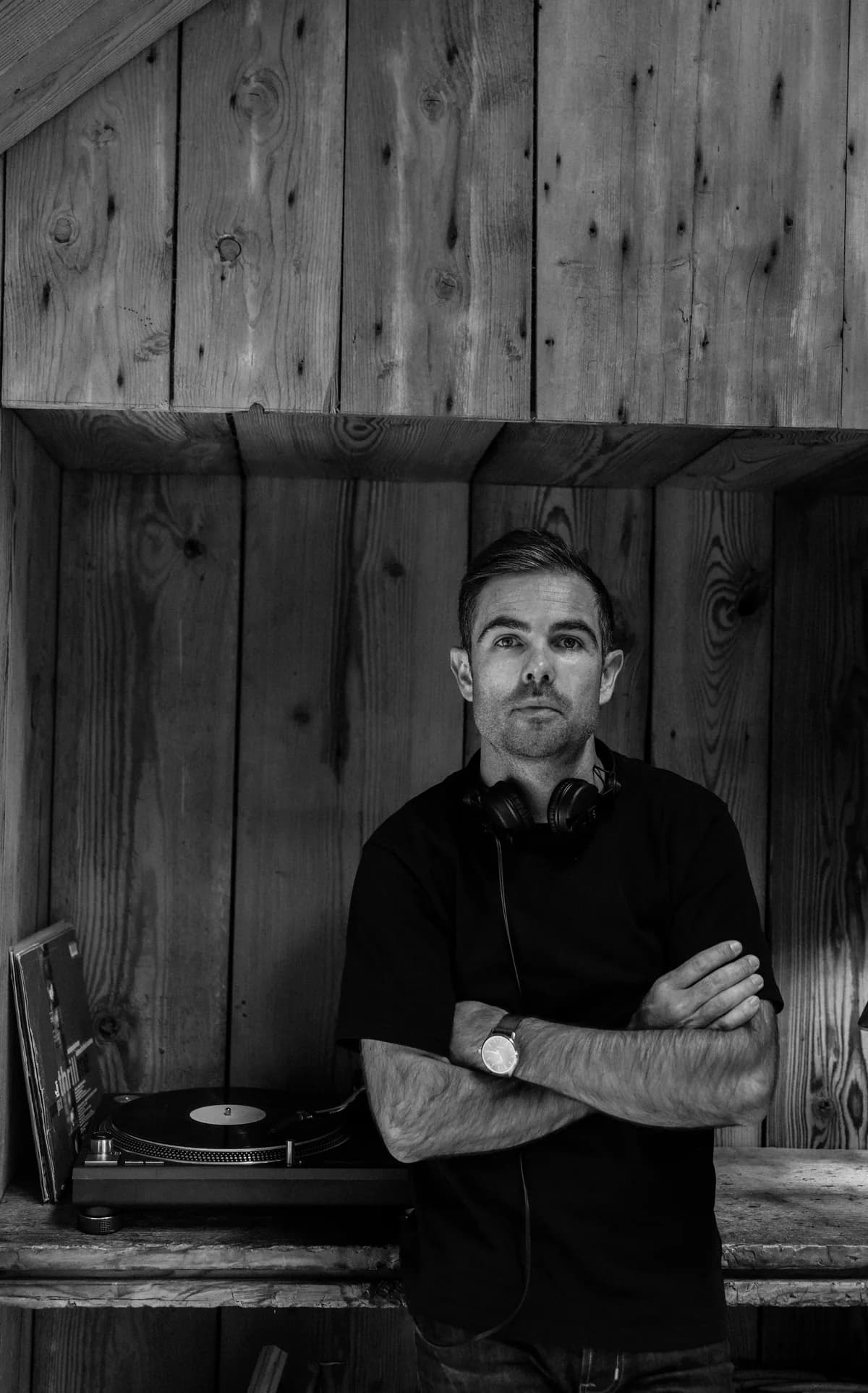 DJ Flo Shot, DJ du réseau, en portrait noir et blanc devant une platine vinyle