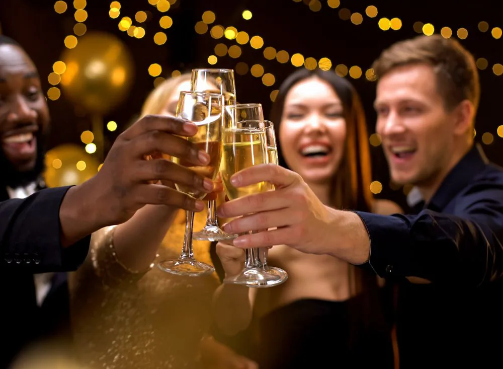Invités trinquant au champagne sous les guirlandes