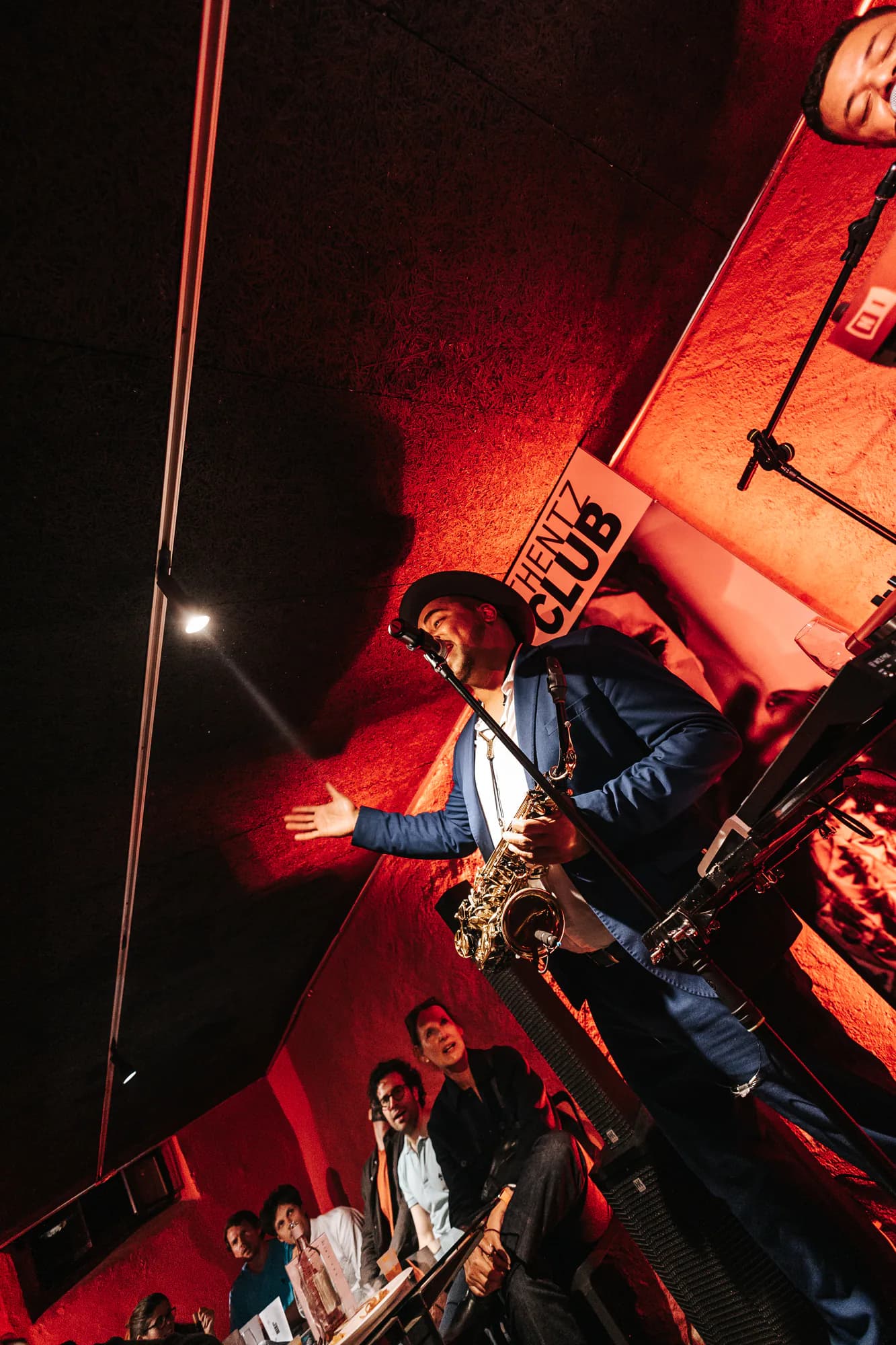 Solo de saxophone sur scène, sous les lumières rouges d'un club