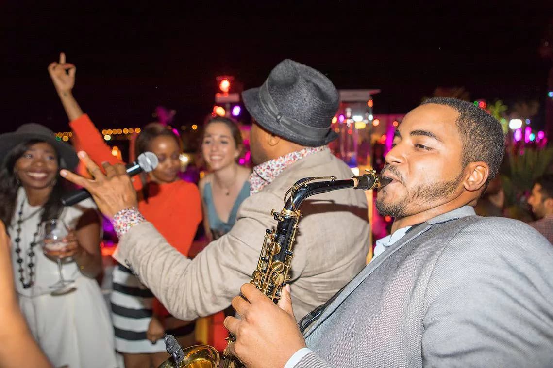 Saxophoniste et chanteur entre les tables pendant une soirée