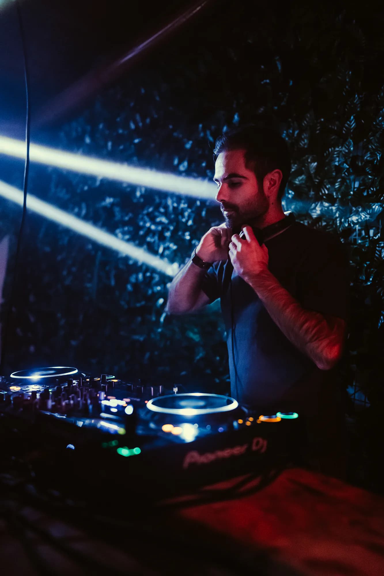 DJ en cabine sous les faisceaux laser devant la foule